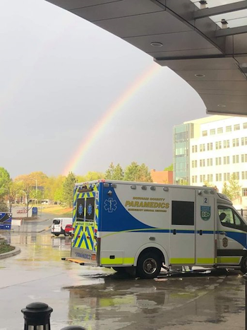 Emergency Medical Services vehicle with rainbow in background