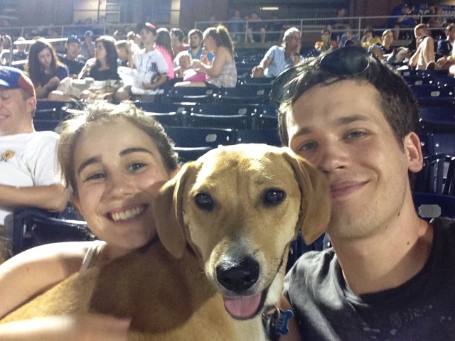 Couple with dog at a baseball game