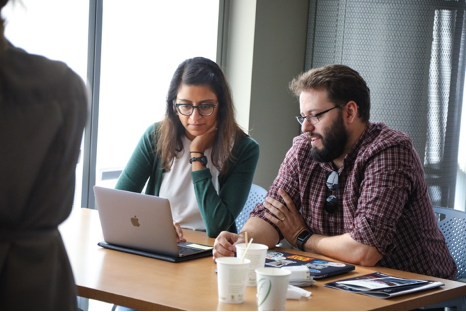 Colleagues collaborate at a shared computer