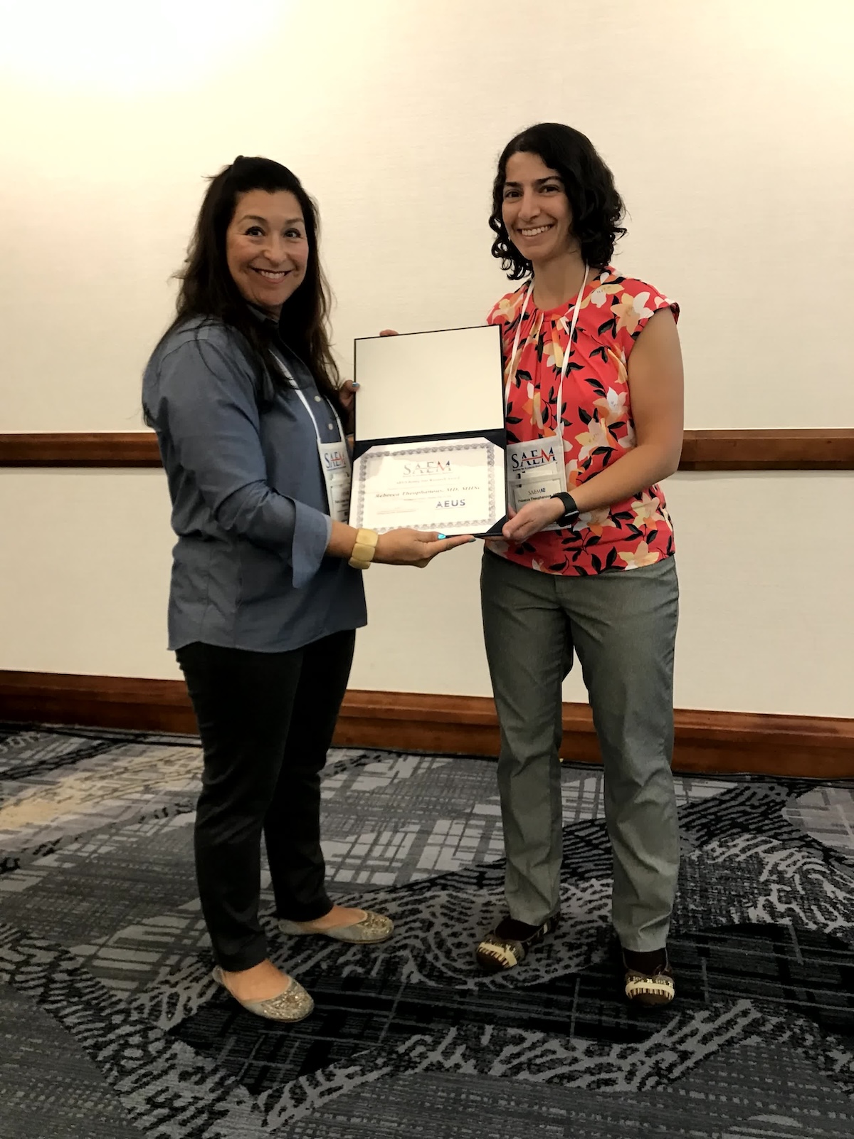 Two women showing an award