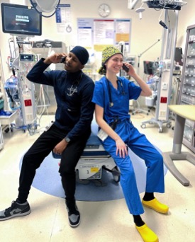 Two residents in scrubs, each talking on a cellphone
