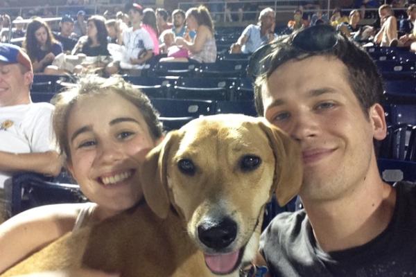Couple with dog at a baseball game