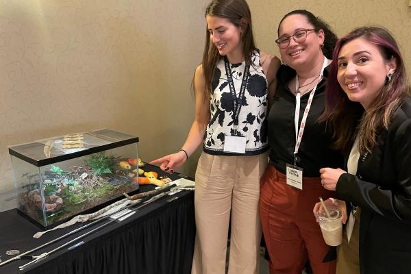 Clinical Research Coordinators Rylee Bledsoe, Rosanna Escobar Spadina, and Tammy Hawley admire a copperhead snake at the international Venom Week Conference.