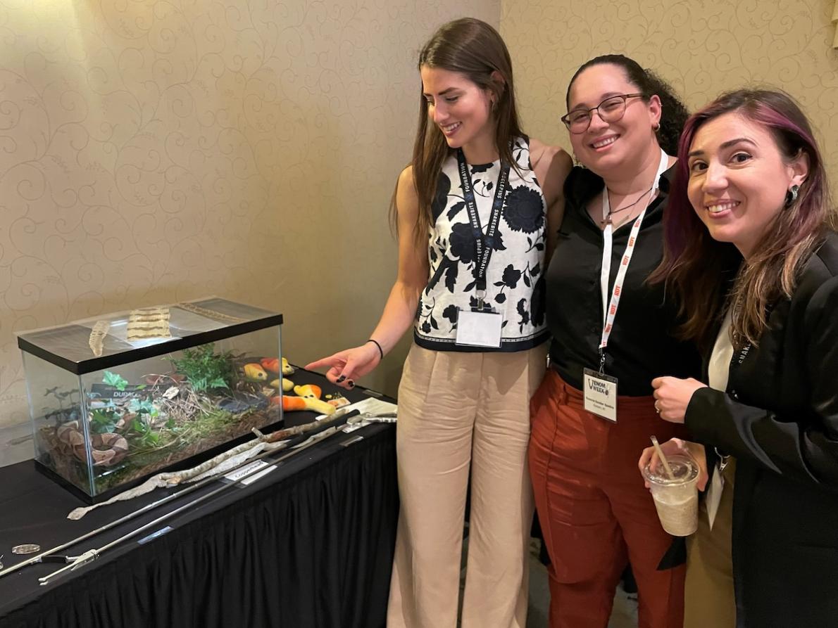 Clinical Research Coordinators Rylee Bledsoe, Rosanna Escobar Spadina, and Tammy Hawley admire a copperhead snake at the international Venom Week Conference.
