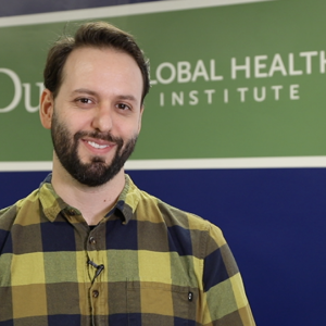 Dr. Joao Vissoci stands in front of the Duke Global Health Institute sign